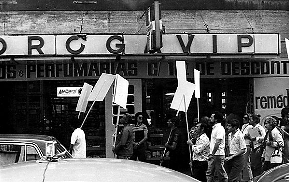 8.  O Branco invade a cidade. Esta ao de rua que conduzir  priso de Fred Forest pela polcia militar da junta ser um golpe sobre o acontecimento mais importante desta XII Bienal de So Paulo. Ela consistir no deslocamento do artista por So Paulo, acompanhado por aproximadamente quinze pessoas carregando cartazes brancos. A provocao era ainda mais evidente, pois o regime da poca proibia o agrupamento de mais de trs pessoas no espao urbano. Os jornalistas da grande imprensa diria brasileira, cmplices objetivos de Fred Forest, tinham anunciado esta ao na vspera, sob o ttulo de Higiene da arte: o branco invade a cidade. De acordo com um itinerrio distribudo, o grupo conduzido por Forest circulou pelo centro de So Paulo passando por todos os lugares simblicos e histricos. Transcorridos quinze minutos, uma multido considervel reuniu-se progressivamente a este cortejo inslito e a circulao foi bloqueada em diferentes pontos da cidade. Este priplo que se desenvolveu por volta de duas horas terminou com a irrupo da polcia, a apreenso dos cartazes e a captura do artista, levado ao DOPS. 